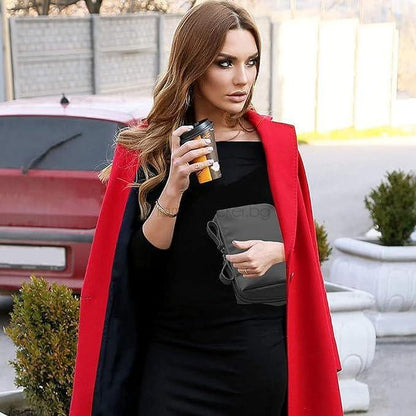 Стилна дама в черна рокля и червено палто, държаща чаша кафе и MiniLuxury водоустойчива чанта за козметика.
