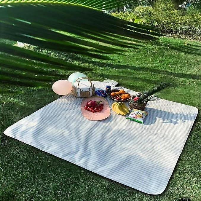 Пикник на зелената трева с голямо одеяло и храна. Идеално за приключения на открито. Удобство и стил за всяко лято!